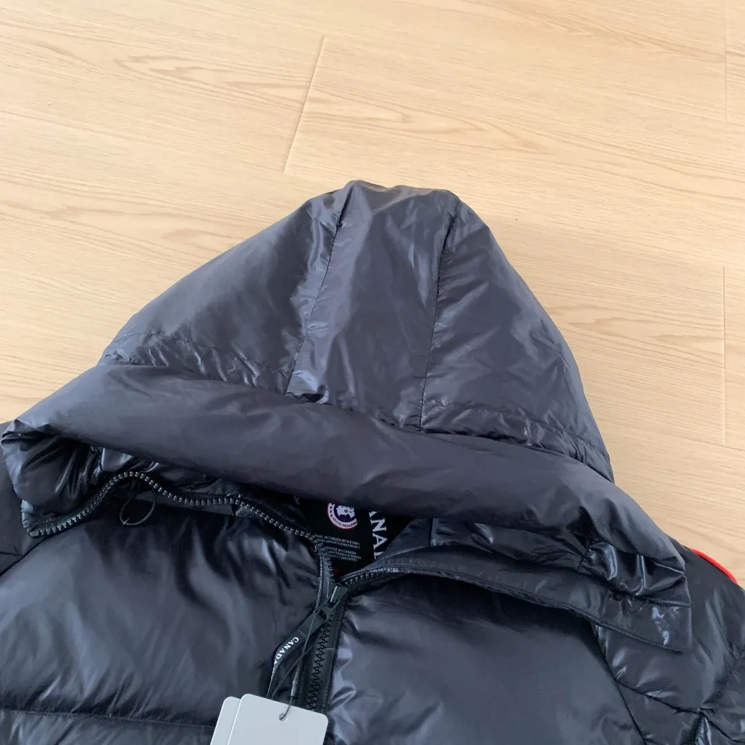 Style number: Y 166 2239L women's model (high version) Canada goose Cypress down jacket Cypress Series' New Arrival allows you to show your difference. This down jacket is an ideal winter piece. This style is filled with white duck down. Featuring a thin, channel-filled construction with lightweight fabrics and trim, it feels lightweight and adds warmth. The suede knit stand-up collar that protects the chin is soft and adds comfort. An adjustable down hood with cord closure adds warmth and protection against the elements. The back is designed with the iconic double-stripe Black reflective decorative stripes, making you more visible in dim environments. The inner layer has removable elastic straps, making the jacket easy to carry on the shoulder and hands-free. The side zipper gusset is breathable when moving. Color: Black Red Label Silver Birch Size: XS-2XL